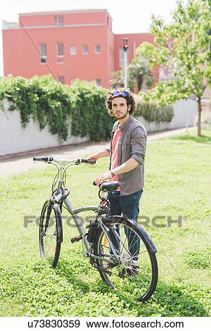 Stock Photo - Man with bicycle in park. Fotosearch