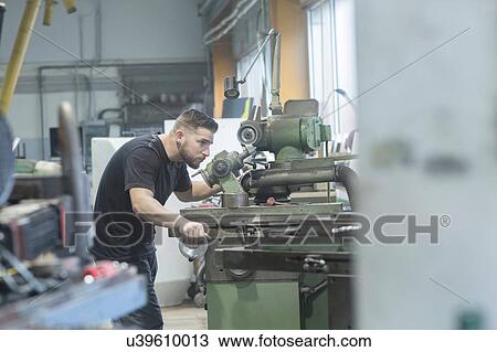 Stock Image - Man working in grinding workshop. Fotosearch