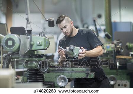 Stock Photo - Man working in grinding workshop. Fotosearch