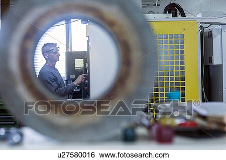 Stock Photograph - Man working in grinding workshop. Fotosearch