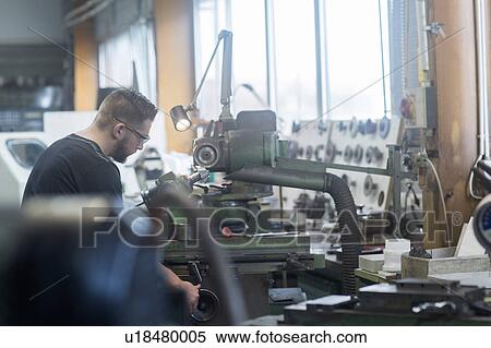 Stock Photography - Man working in grinding workshop. Fotosearch