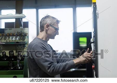 Stock Photography - Man working in grinding workshop. Fotosearch