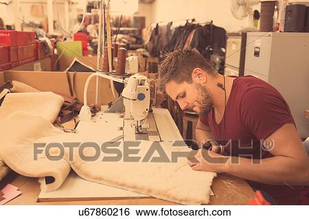 Stock Photograph - Man working in leather jacket manufacturers. Fotosearch