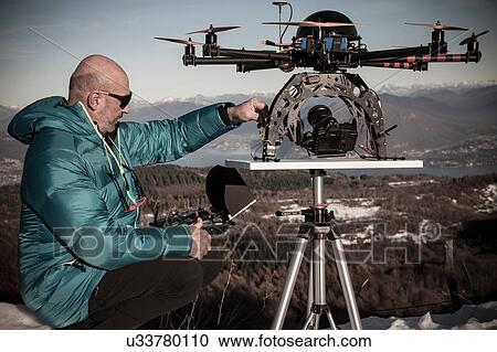Mature man preparing to fly drone, Stresa, Piedmont, Italy View Large Photo Image Stock Image - Mature man preparing to fly drone, Stresa, Piedmont, Italy. Fotosearch