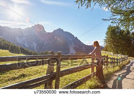 Mature woman leaning against fence looking out at Dolomites, Sexten, South Tyrol, Italy View Large Photo Image Stock Image - Mature woman leaning against fence looking out at Dolomites, Sexten, South Tyrol, Italy. Fotosearch