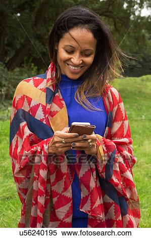 Stock Photography - Mature woman outdoors, using smartphones. Fotosearch