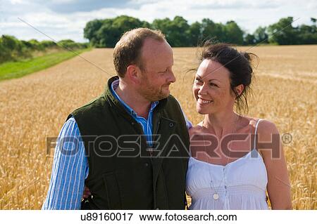 Mid adult couple walking through field, smiling View Large Photo Image Stock Photo - Mid adult couple walking through field, smiling. Fotosearch