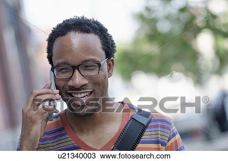 Stock Image - Mid adult man talking on phone. Fotosearch