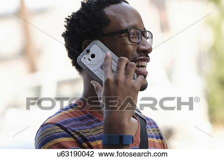 Mid adult man talking on phone View Large Photo Image Stock Image - Mid adult man talking on phone. Fotosearch