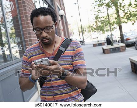 Mid adult man with phone in street View Large Photo Image Stock Photo - Mid adult man with phone in street. Fotosearch