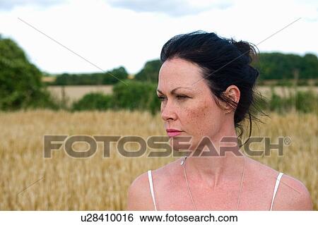 Mid adult woman standing in field, looking away View Large Photo Image Stock Photograph - Mid adult woman standing in field, looking away. Fotosearch