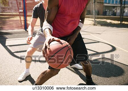 Mid section of two male basketball players practising on basketball court View Large Photo Image Stock Photograph - Mid section of two male basketball players practising on basketball court. Fotosearch