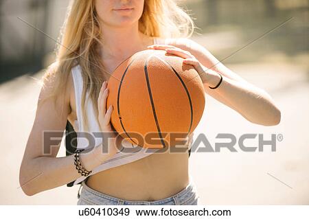 Mid section of young woman practising on basketball court View Large Photo Image Stock Photo - Mid section of young woman practising on basketball court. Fotosearch