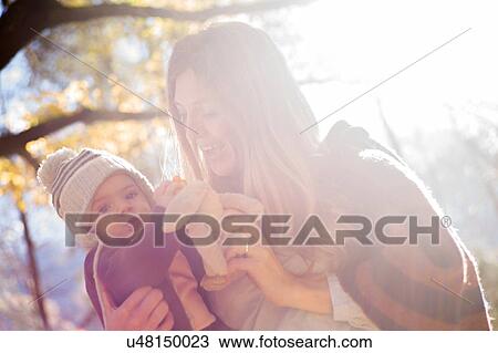 Stock Image - Mother and baby with cuddly toy in forest. Fotosearch