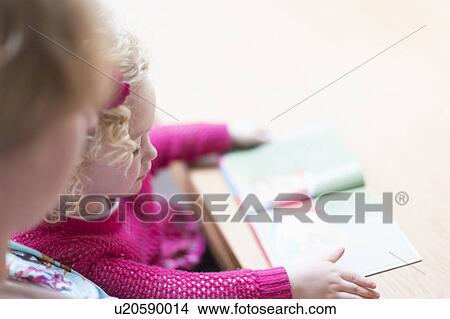Picture - Mother and daughter (4-5) reading book. Fotosearch
