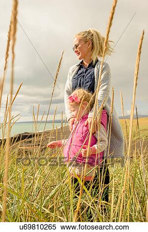 Mother and daughter in field, looking at view View Large Photo Image Stock Photography - Mother and daughter in field, looking at view. Fotosearch