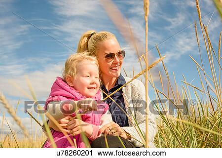 Mother and daughter in wheat field, looking at view View Large Photo Image Stock Image - Mother and daughter in wheat field, looking at view. Fotosearch