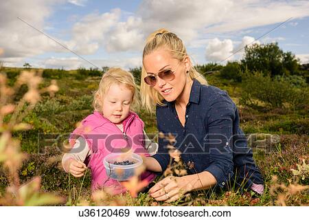 Mother and daughter outdoors, picking blueberries View Large Photo Image Stock Photo - Mother and daughter outdoors, picking blueberries. Fotosearch