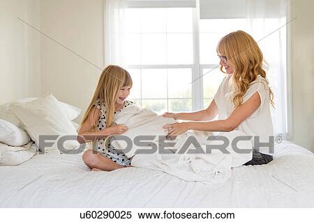 Mother and daughter playing on bed together View Large Photo Image Stock Photography - Mother and daughter playing on bed together. Fotosearch