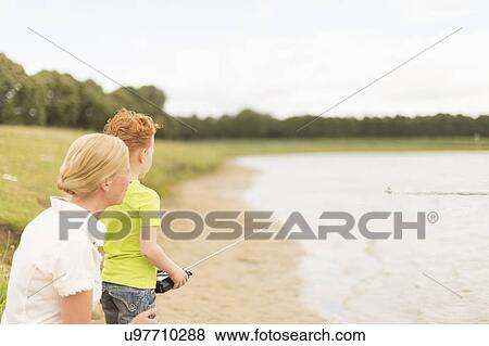 Mother and son (8-9) playing with radio controlled motorboat on lake View Large Photo Image Stock Photo - Mother and son (8-9) playing with radio controlled motorboat on lake. Fotosearch