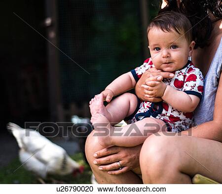 Stock Image - Mother and son relaxing in garden on summer day. Fotosearch