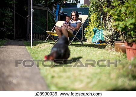 Stock Photograph - Mother and son relaxing in garden on summer day. Fotosearch