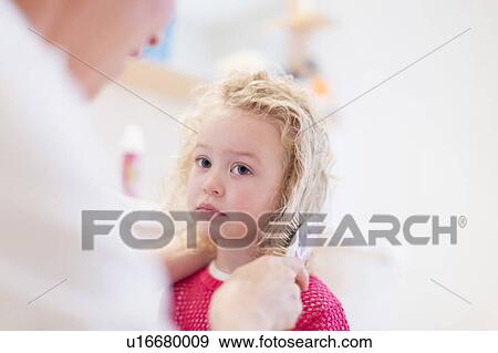 Stock Photo - Mother brushing daughter's (4-5) hair. Fotosearch