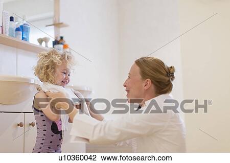 Mother helping daughter (4-5) get dressed View Large Photo Image Stock Image - Mother helping daughter (4-5) get dressed. Fotosearch
