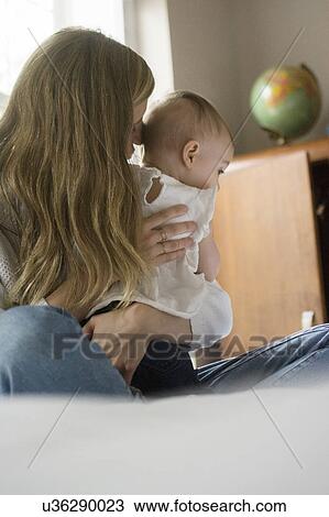 Stock Image - Mother hugging daughter (18-23 months). Fotosearch