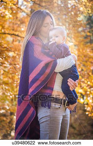 Mother in forest kissing baby girl on forehead View Large Photo Image Stock Image - Mother in forest kissing baby girl on forehead. Fotosearch