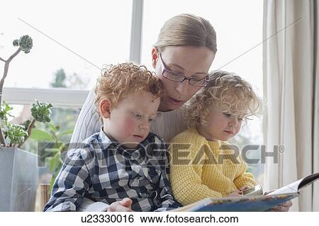 Mother reading to children (4-5, 8-9) in living room View Large Photo Image Stock Photograph - Mother reading to children (4-5, 8-9) in living room. Fotosearch