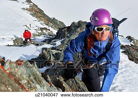 Stock Photo - Mountaineer climbing up snow covered mountain, Saas Fee, Switzerland. Fotosearch