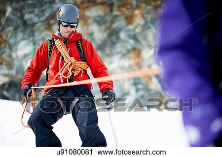 Mountaineer descending snow-covered mountain View Large Photo Image Stock Image - Mountaineer descending snow-covered mountain. Fotosearch