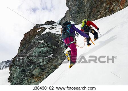 Mountaineers ascending snow-covered mountain, Saas Fee, Switzerland View Large Photo Image Stock Image - Mountaineers ascending snow-covered mountain, Saas Fee, Switzerland. Fotosearch