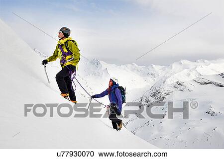 Stock Image - Mountaineers ascending snow-covered mountain, Saas Fee, Switzerland. Fotosearch