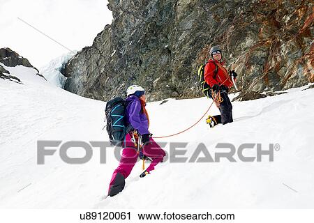 Stock Image - Mountaineers ascending snow-covered mountain, Saas Fee, Switzerland. Fotosearch