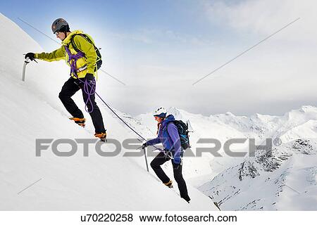 Stock Photo - Mountaineers ascending snow-covered mountain, Saas Fee, Switzerland. Fotosearch