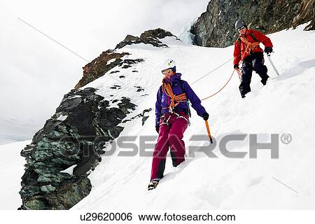 Mountaineers descending snow-covered mountain, Saas Fee, Switzerland View Large Photo Image Stock Photograph - Mountaineers descending snow-covered mountain, Saas Fee, Switzerland. Fotosearch