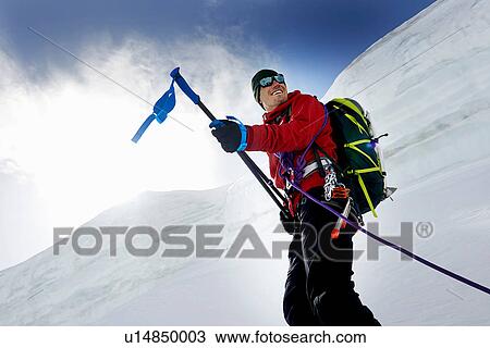 Stock Image - Mountaineers holding walking poles looking away smiling, Saas Fee, Switzerland. Fotosearch
