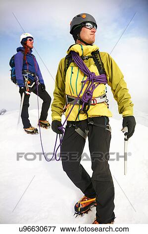 Mountaineers on snow-covered landscape looking away View Large Photo Image Stock Photo - Mountaineers on snow-covered landscape looking away. Fotosearch