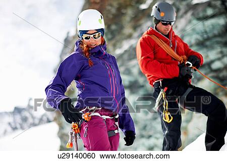 Stock Image - Mountaineers preparing climbing equipment. Fotosearch