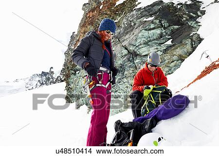 Mountaineers preparing equipment on snow-covered mountain, Saas Fee, Switzerland View Large Photo Image Picture - Mountaineers preparing equipment on snow-covered mountain, Saas Fee, Switzerland. Fotosearch