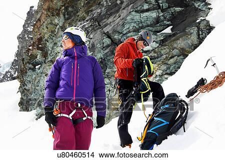 Mountaineers preparing equipment on snow-covered mountain, Saas Fee, Switzerland View Large Photo Image Picture - Mountaineers preparing equipment on snow-covered mountain, Saas Fee, Switzerland. Fotosearch