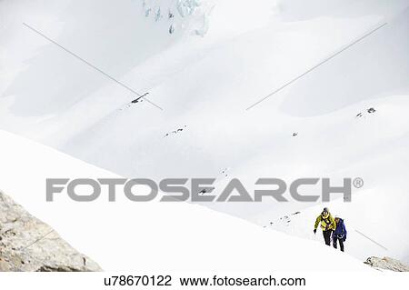 Stock Image - Mountaineers ski touring on snow-covered mountain, Saas Fee, Switzerland. Fotosearch