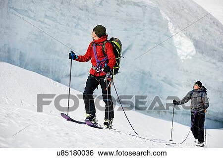Stock Photograph - Mountaineers ski touring on snow-covered mountain, Saas Fee, Switzerland. Fotosearch