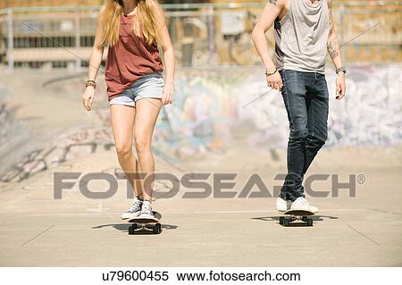 Neck down view of female and male skateboarders skateboarding in skatepark View Large Photo Image Stock Photography - Neck down view of female and male skateboarders skateboarding in skatepark. Fotosearch