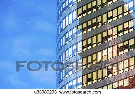 Stock Image - New York, New York City, Curved office building with blue sky in background. Fotosearch