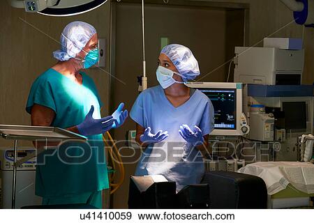Stock Photo - Nurse and surgeon having discussion in hospital theatre. Fotosearch