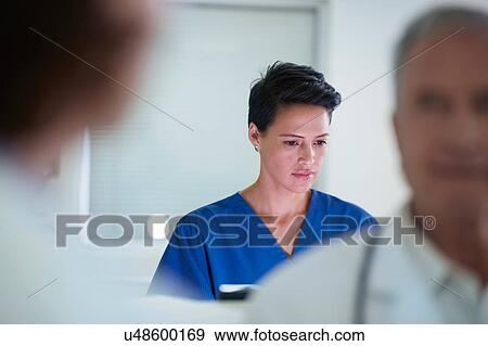 Stock Photo - Nurse busy at nurses station in hospital. Fotosearch