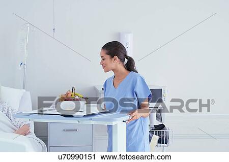 Nurse serving lunch to senior female patient in hospital bed View Large Photo Image Stock Image - Nurse serving lunch to senior female patient in hospital bed. Fotosearch